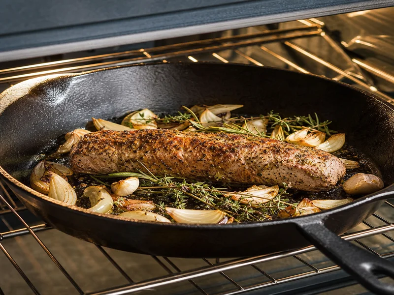 Skillet of pork tenderloin roasting in the oven