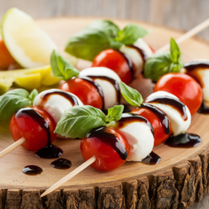Mini Caprese Skewers with Balsamic Glaze featuring vibrant cherry tomatoes, creamy mozzarella pearls, fresh basil leaves, and a glossy drizzle of tangy balsamic glaze. A perfect appetizer for parties, picnics, or healthy snacking.